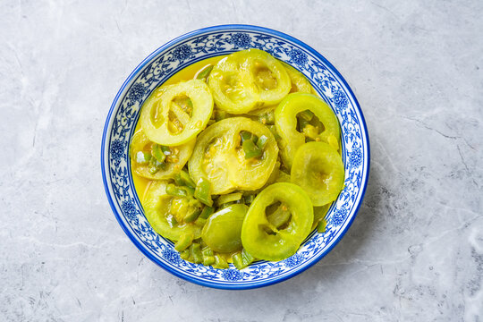 A plate of vegetables on the dining table&mdash;stir-fried green tomatoes.
