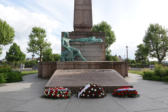 The bronze sculpture group at the base of the G&euml;lle Frau war memorial in Luxembourg City, depicting a seated bronze soldier mourning a fallen comrade lying atop a stone plinth.