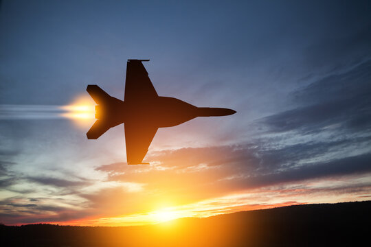 Air Force Day. Aircraft silhouette on background of sunset. Combat flight of interceptor on a mission.
