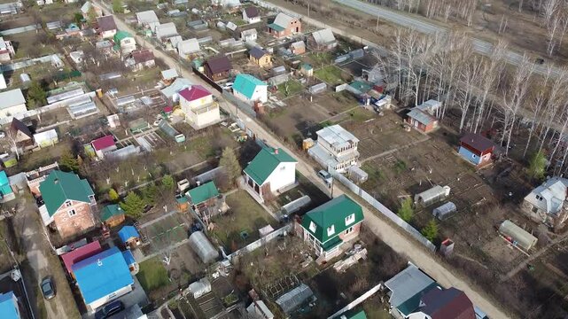 Aerial view of quiet residential neighborhood with colorful rooftops. Trees line roads and yards, creating peaceful suburban atmosphere. , so emotions not applicable