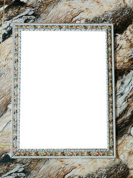 Ornate stone frame against a blurred background of weathered rock and foliage