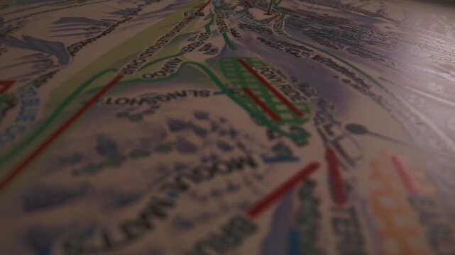 Close-up explores marked ski runs and resort facilities across a printed alpine trail map