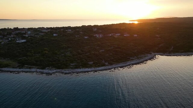 A stunning aerial drone shot capturing the warm golden sunset over the Sotorisce bay and Mulj harbor area on Silba Island, Croatia. The perspective showcases the sheltered marina filled with boats