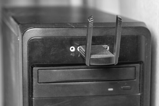 Old dirty front panel of PC with a USB Wi-Fi adapter. Front focus