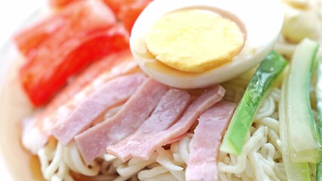 Ramen Noodle Bowl with Egg, Ham, Crab and Fresh Vegetable Garnish