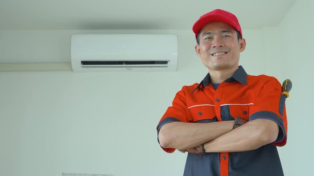 Professional air conditioning technician standing with arms crossed in a residential room