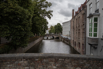 Obraz premium Canal scene with stone bridge and buildings in Bruges