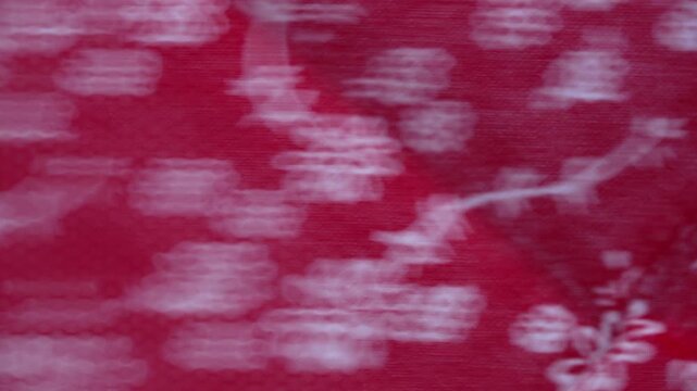 Red textile fabric with white floral pattern moving