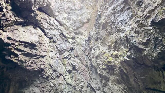 Sunlight shines through a steep canyon shaft at Ruskeala, Karelia. Looking up toward the open sky evokes awe and wonder. The majestic rock walls bring a feeling of peaceful quiet.