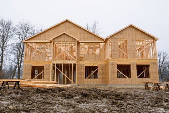 The Timber-Framed House Under Construction with Wooden Framing and Scaffolding