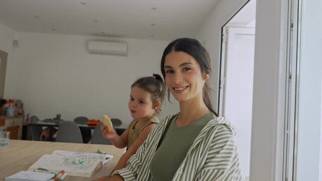 Mother working from home with daughter nearby