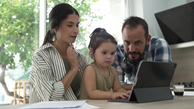 Young family using tablet computer in the kitchen