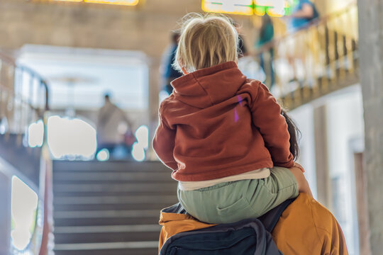 Dad walks through a cultural museum with a small child on his shoulders, showing family outing, educational travel and parenting concept