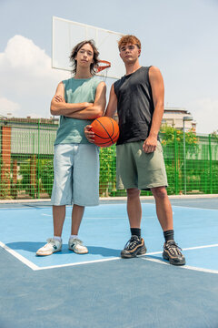 vertical Multicultural young men holding basketball on court