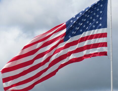 Fluttering American flag against blue sky and clouds