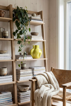 Uplifting scandinavian corner with ladder bookshelf, yellow vase, trailing pothos and throw