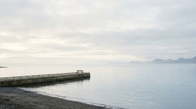 Calm water dock and distant shoreline under overcast sky