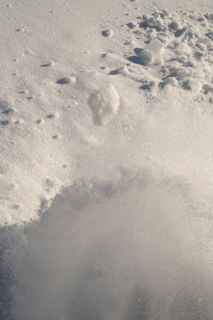 Close up texture of a fresh snow surface with soft wind patterns