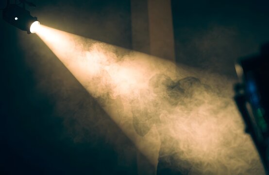 Close up fog machine creating thick artificial smoke effect in dark room
