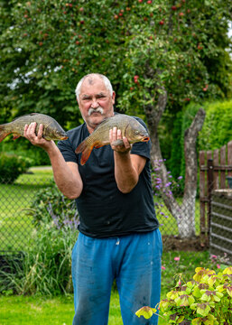 photo of an angler showing off his caught fish, fishing concept, carp fishing, healthy eating,