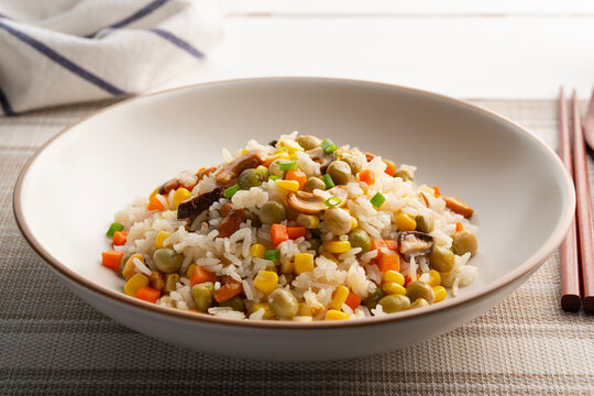 Whole Grain Fried Rice.vegan fried rice with shiitake mushroom ,Cashew nuts ,carrot ,corn and green pea in white plate.Vegetarian Festival.