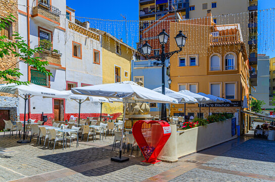 Calpe, Spain, May 30, 2025: Old town Calpe city historical centre with street restaurant outdoor cafe on Plaza Mariners square, typical houses colorful buildings in sunny day, Valencian Community
