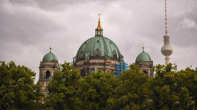 Berlin Cathedral domes and Fernsehturm framed by trees