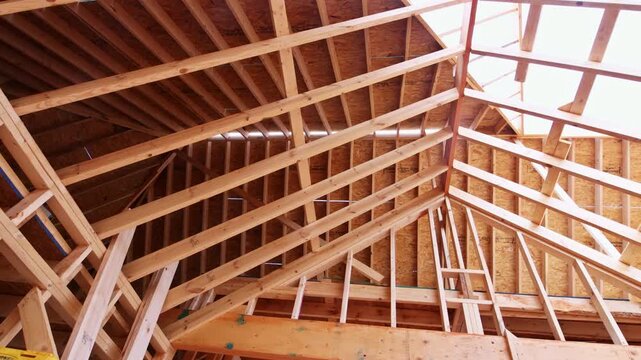 Workers are building roof structure using wooden beams for construction in progress