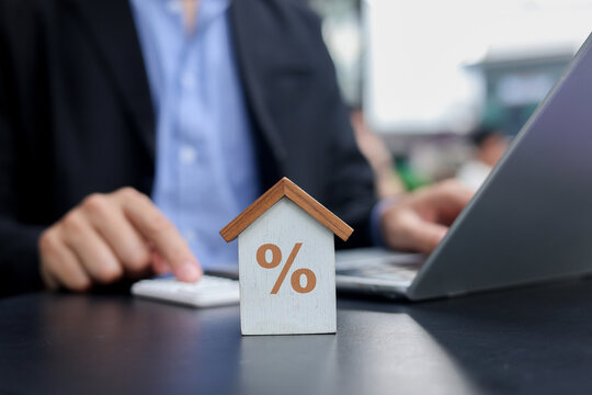close up on house model with man working about check and summary expense of home loan mortgage for refinance plan , people lifestyle concept