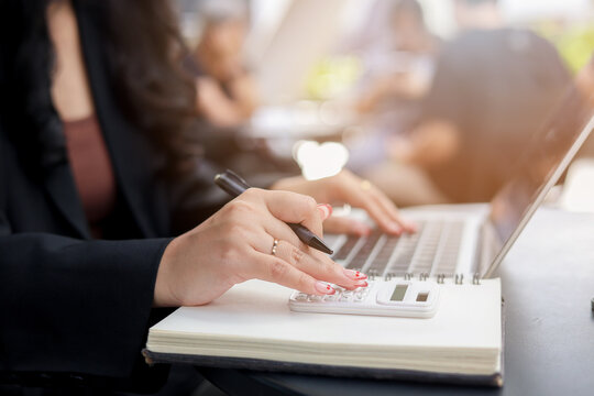 close up accountant businesswoman press on calculator to check about profit or budget and debt of company at office desk for business financial concept