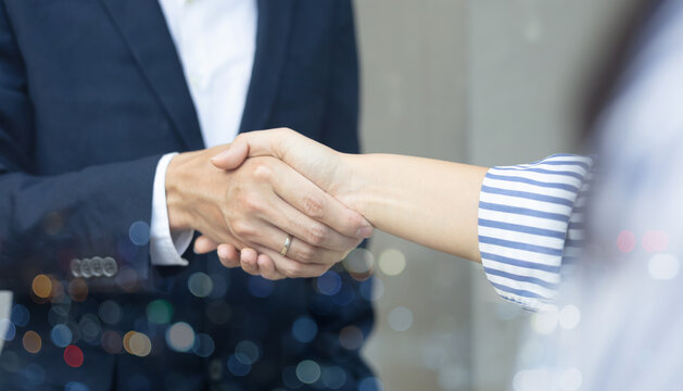 close up business man handshake fro dealing goal isolated on blurred city background,agreement financial commercial concept.