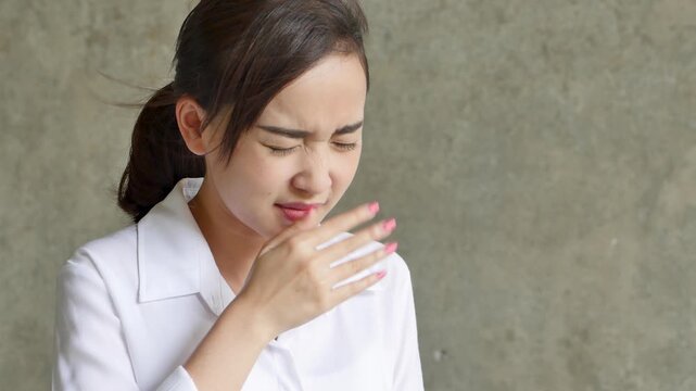 female southeast asian young adult recovering from cold and flu, coughing in living room then feeling better
