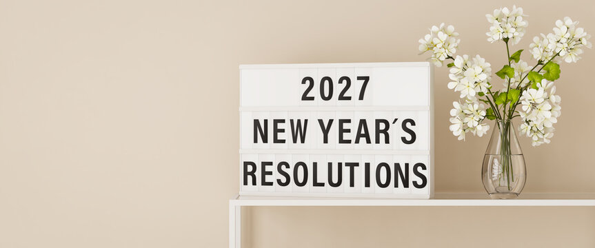 A lightbox displaying the words "2027 New Year's Resolutions" on a shelf with a vase of Gerbera flowers. Web banner format with copy space