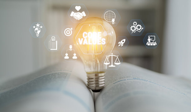 Light bulb with glowing core values concept, symbols of integrity, teamwork, innovation, and achievement on open book in business environment Fluxor.