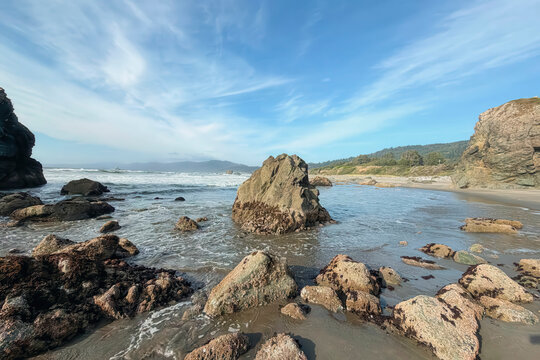 Ocean water around rocks along a sandy beach near Brookings Oregon