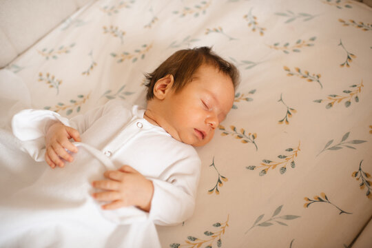 Cute infant baby sleeping in crib close up top view. Childhood.