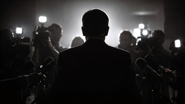 Silhouette of a businessman facing reporters and microphones at a press conference, representing media attention, public relations, leadership, and corporate news