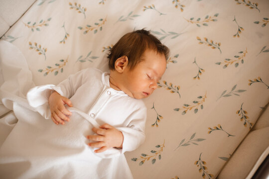 Cute infant baby sleeping in crib close up top view. Childhood.
