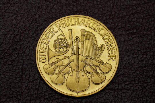 Top Down Macro Shot of the heads side of a "Wiener Philharmoniker 1/4 unze 1992" golden coin on leather backround.