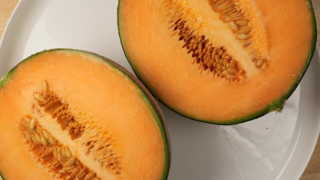Ripe cantaloupe melon cut in half rotating