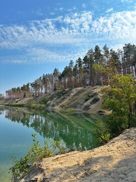 Scenic Quarry Lake with Emerald Water and Pine Forest Reflection