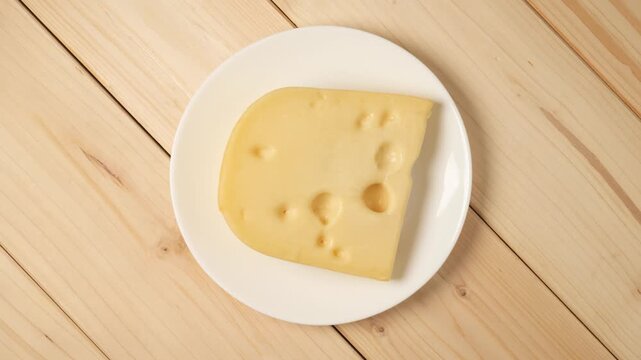 Slice of swiss cheese rotating on a plate