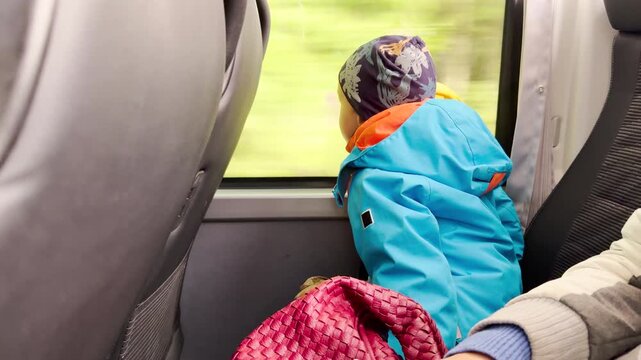 A young boy looks out a bus window while traveling through Karelia. The cozy ride brings a calm and joyful feeling of wonder.