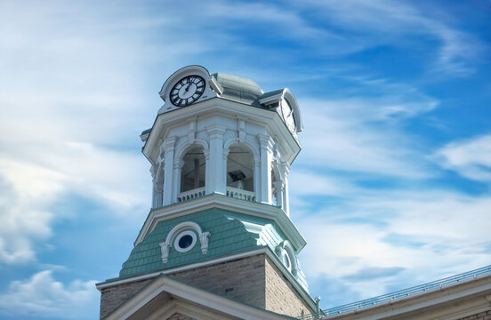 A bell tower and clock against soft clouds, blue sky, sunny day, nobody