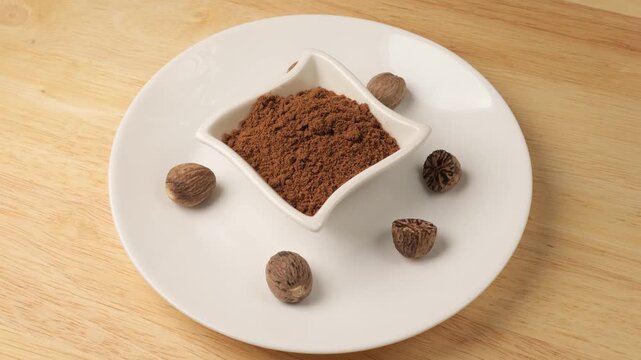 Aromatic nutmeg spice powder rotating on a plate
