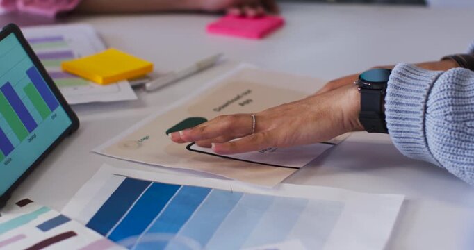 After placing mockup, pair of hands are aligning and revealing pages on white table