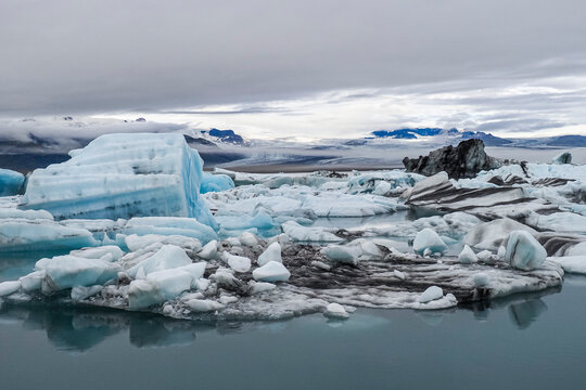 Panoramic view. National Park with calm water, large blue icebergs or melting ice. J&ouml;kuls&aacute;rl&oacute;n or "Glacial River Lagoon" is the largest and most active glacial lake in the southern part of Vatnaj&ouml;kull