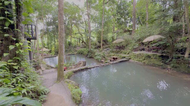 Kathu Dam waterfall water gently flowing down the rocks surrounded by lush green trees flowers and tables Patong on the Island of Phuket Thailand