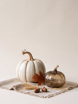 Thanks giving poster with text space, A classic autumnal still life composition featuring a white pumpkin, a metallic bronze pumpkin, dried leaf and acorn.