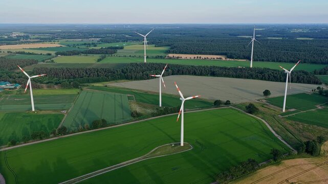 Wind mill for renewable electric energy production. Windmill in a rural area. Offshore wind park. Wind turbines farm. Alternative renewable energy generation. Green energy footage